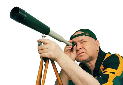 Man, an astronomer looking through a telescope.
