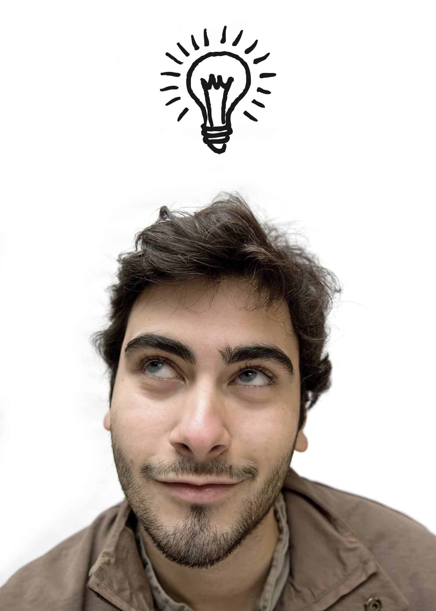 Happy casual man looking up over white background having an idea
