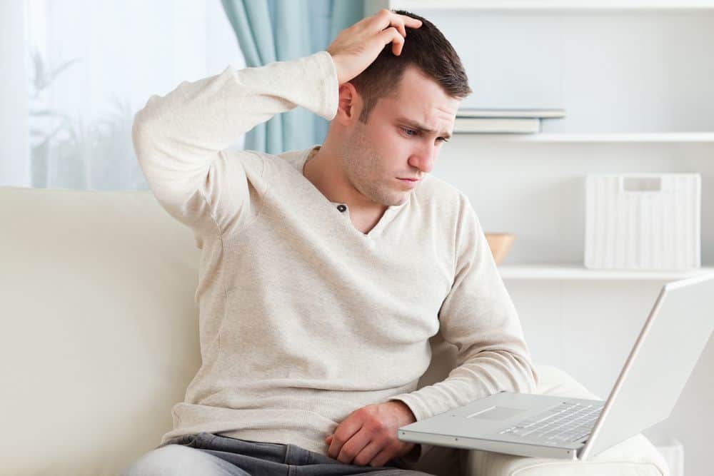 Confused man using a notebook