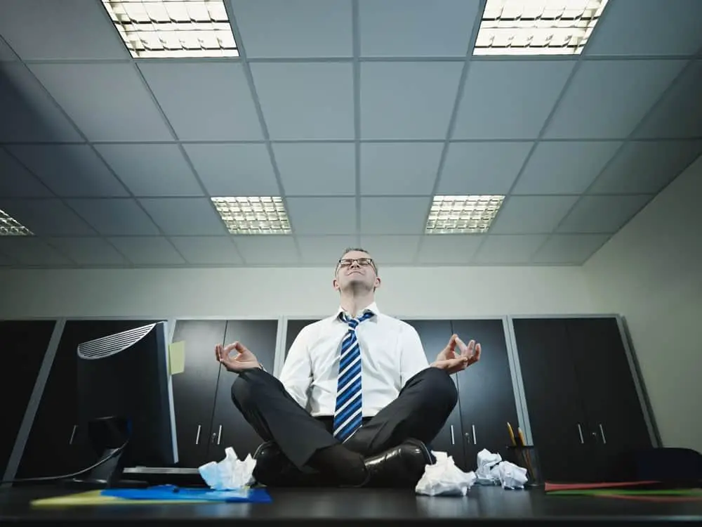 businessman doing yoga in office