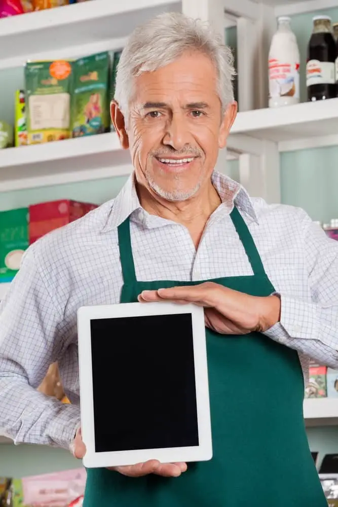 Male Owner Showing Digital Tablet In Store