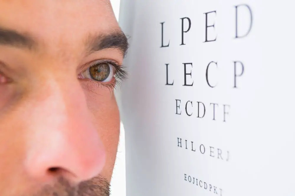 Focused man on eye test letters on white background