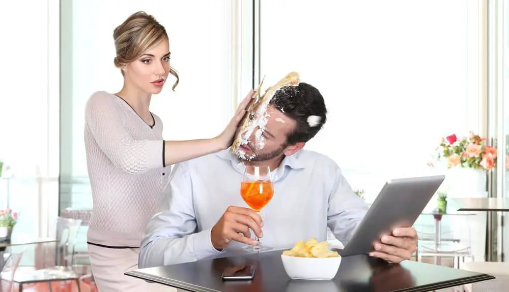 angry woman pulling cake in face to boyfriend cheating
